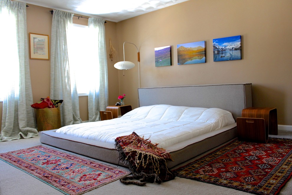 他の地域にある広いトランジショナルスタイルのおしゃれな主寝室 (ベージュの壁、カーペット敷き、グレーの床) のインテリア
