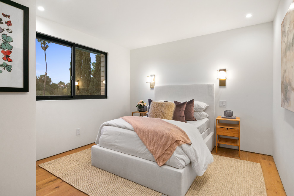Idee per una camera degli ospiti design di medie dimensioni con pareti bianche, pavimento in legno massello medio e pavimento marrone