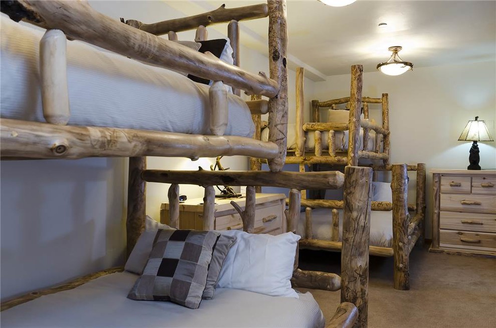 Medium sized rustic guest bedroom in Denver with white walls, carpet and no fireplace.