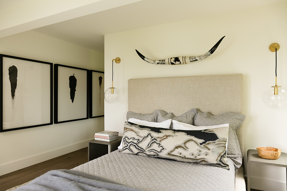 Modelo de habitación de invitados marinera con paredes beige, suelo de madera en tonos medios y suelo marrón