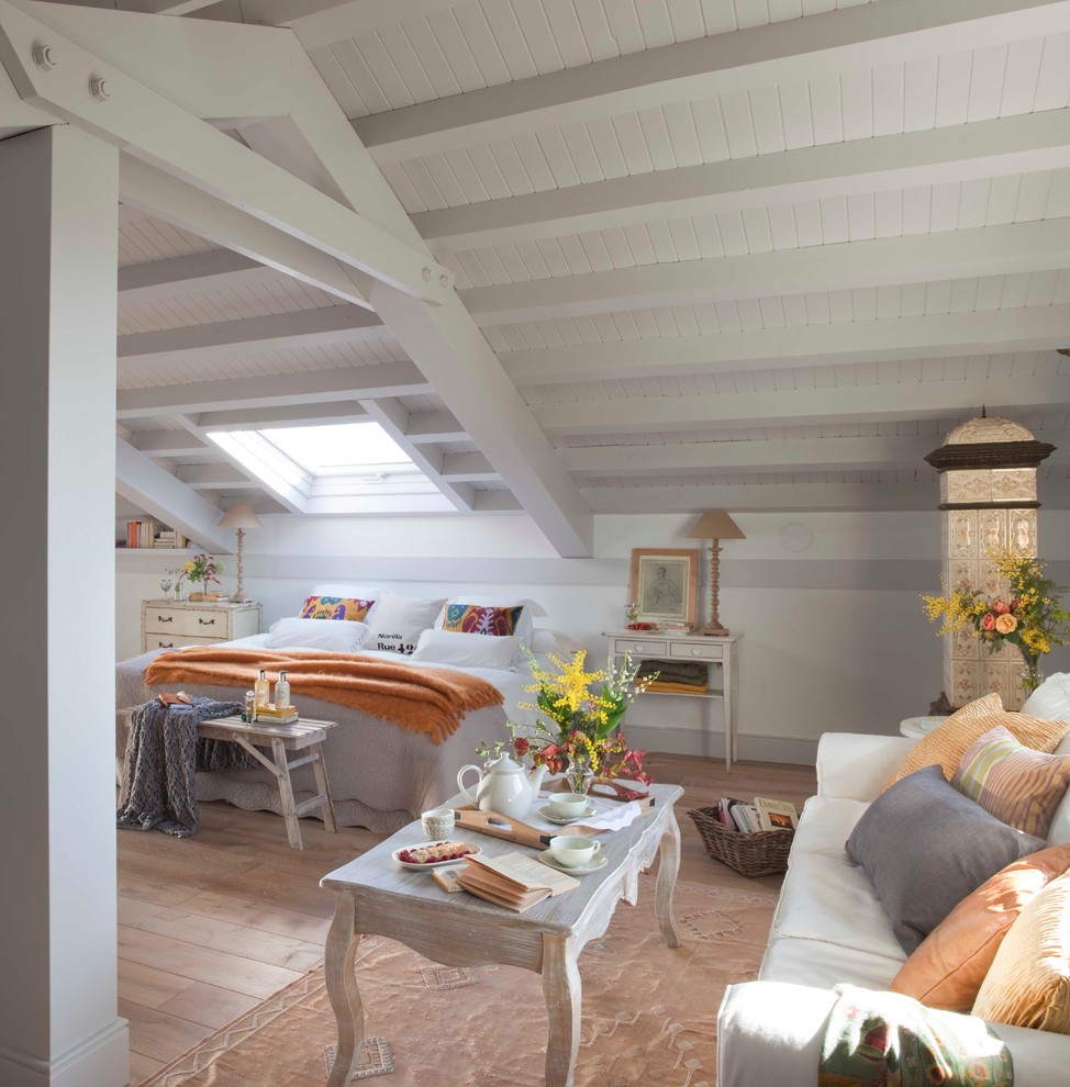 マドリードにある巨大なシャビーシック調のおしゃれな客用寝室 (白い壁、無垢フローリング、暖炉なし、勾配天井)