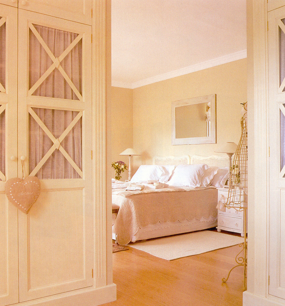 Foto de dormitorio principal clásico de tamaño medio con paredes beige y suelo de madera en tonos medios