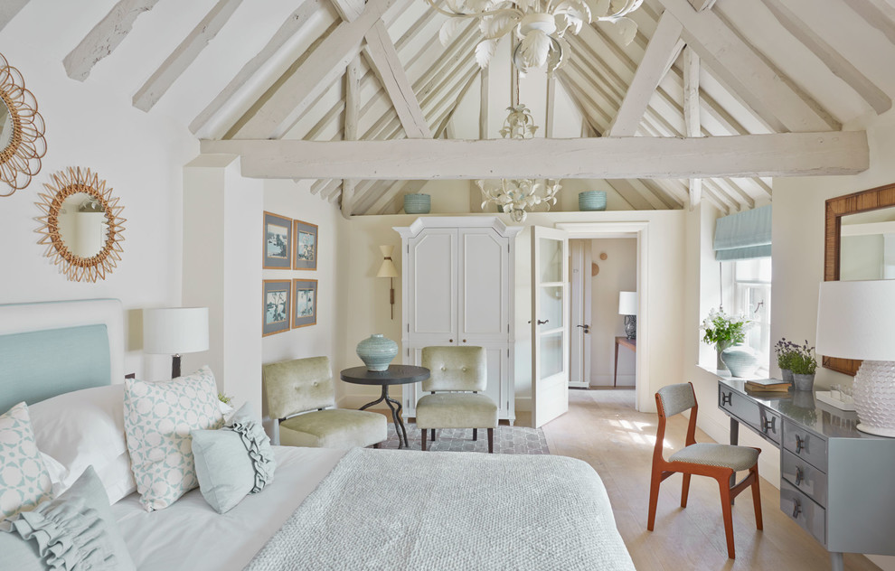 Imagen de dormitorio principal de estilo de casa de campo sin chimenea con paredes blancas, suelo de madera clara y con escritorio