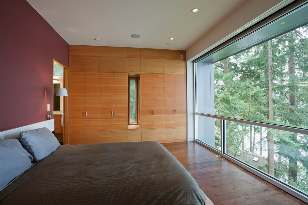 На фото: спальня среднего размера в современном стиле с паркетным полом среднего тона и коричневым полом с