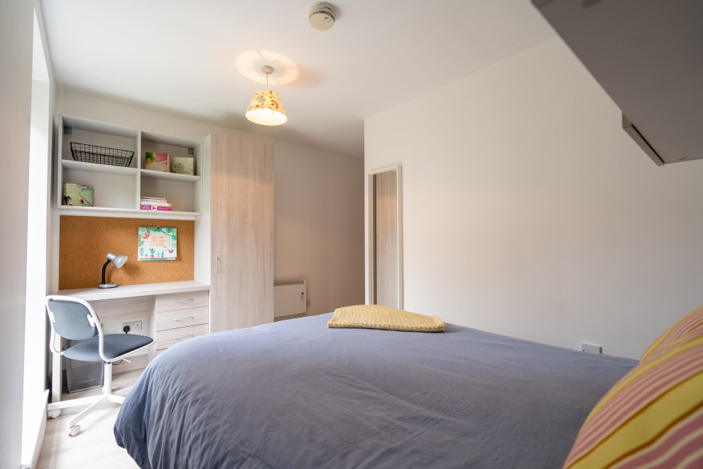 Immagine di una piccola camera degli ospiti moderna con pareti bianche, parquet chiaro e pavimento marrone