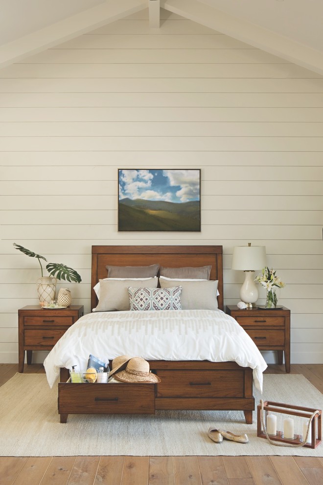 Imagen de habitación de invitados tropical de tamaño medio sin chimenea con paredes blancas y suelo de madera en tonos medios