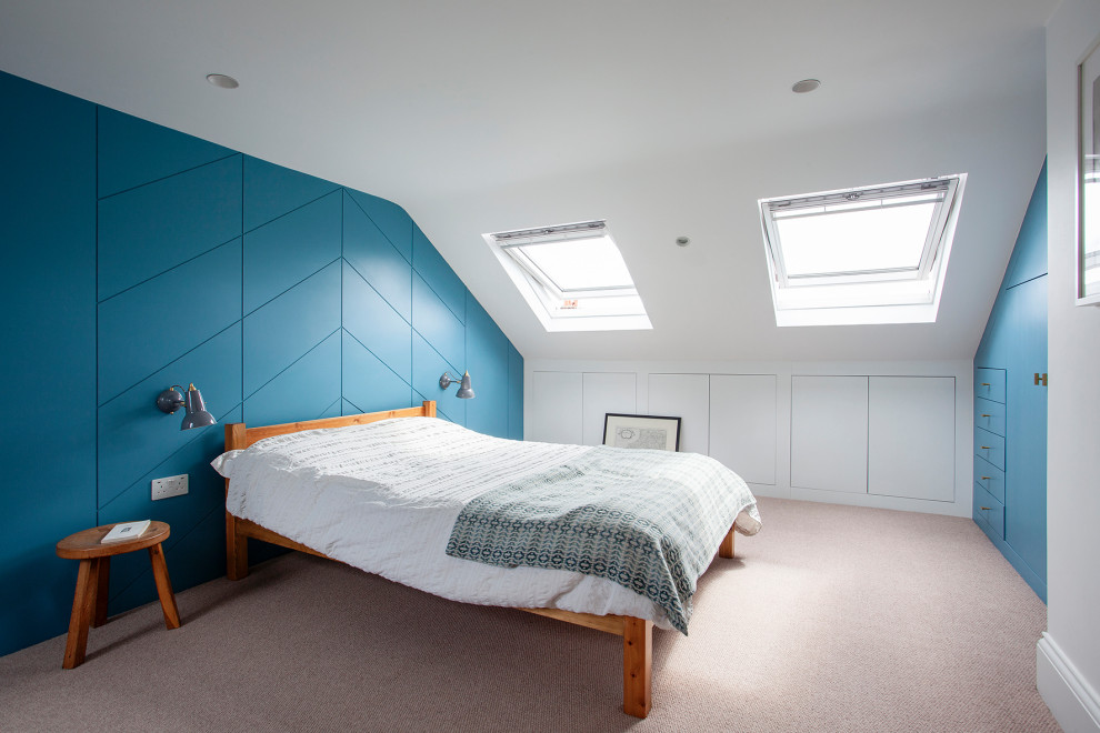 Example of a small 1950s guest carpeted, beige floor and wall paneling bedroom design in London with blue walls