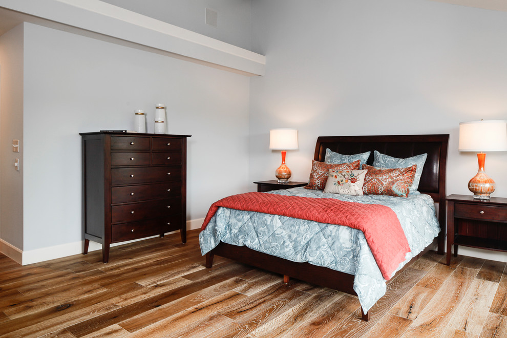 Ejemplo de dormitorio principal clásico renovado grande con paredes azules y suelo de madera clara