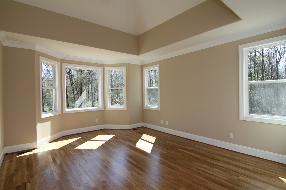 Exemple d'une chambre parentale chic de taille moyenne avec un mur beige et un sol en bois brun.