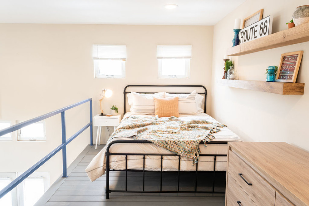 Aménagement d'une petite chambre mansardée ou avec mezzanine moderne avec parquet peint et un sol bleu.