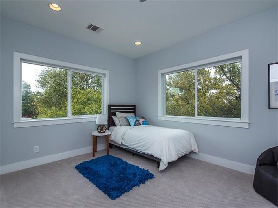 This is an example of a medium sized classic guest bedroom in Austin with blue walls, carpet, no fireplace and grey floors.