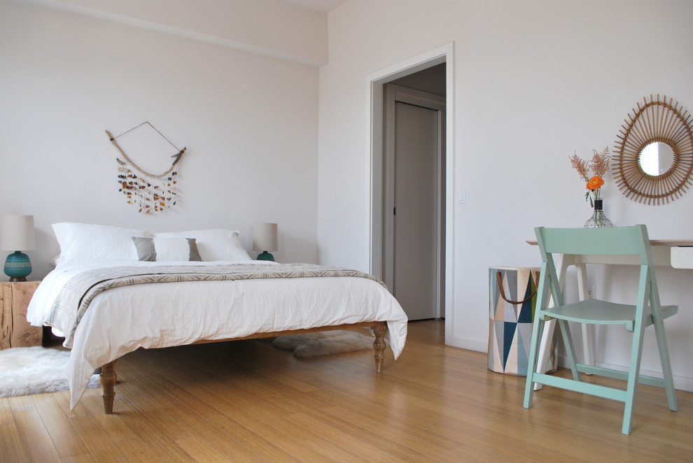 Photo of a scandi bedroom in New York with white walls, light hardwood flooring and no fireplace.