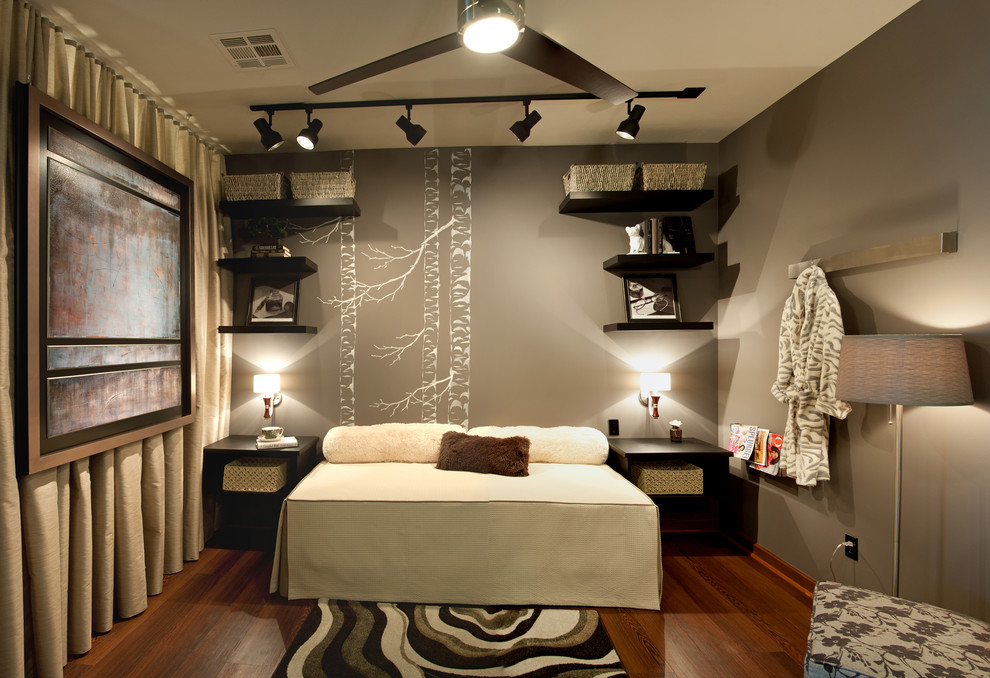 Diseño de habitación de invitados contemporánea de tamaño medio sin chimenea con paredes grises, suelo de madera oscura y suelo marrón