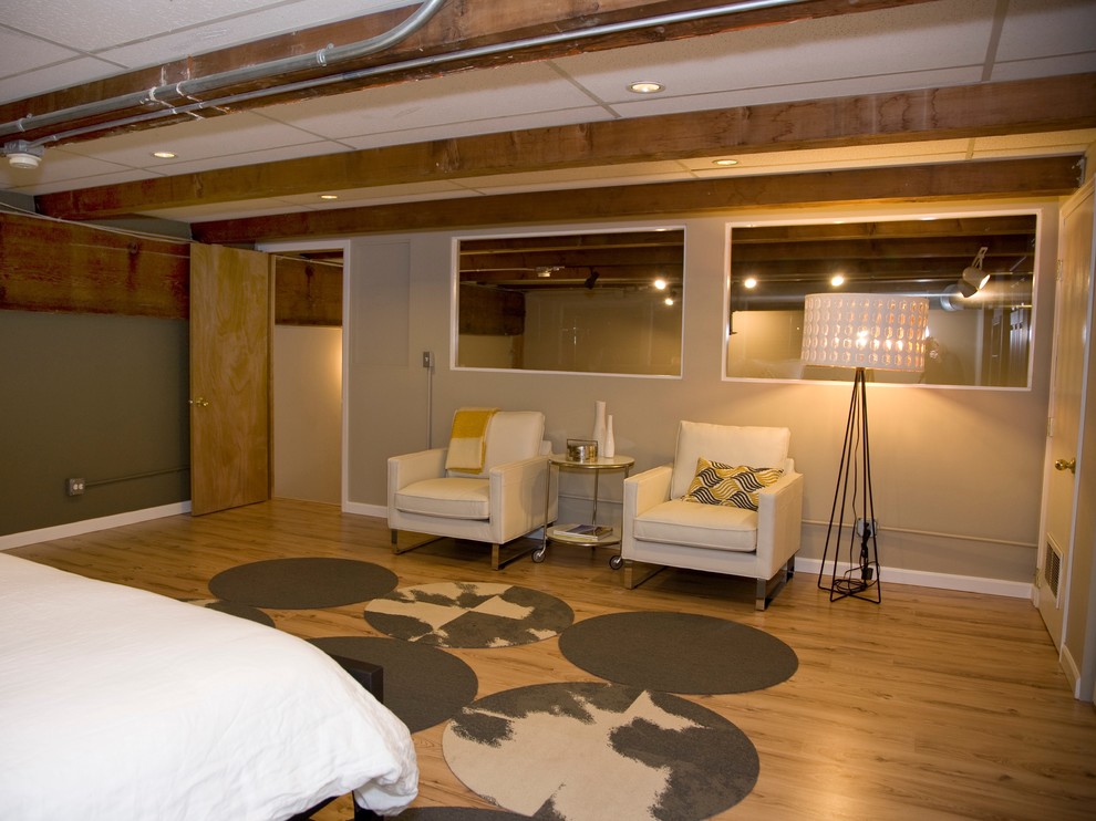 Foto de dormitorio tipo loft minimalista de tamaño medio sin chimenea con paredes beige y suelo de madera clara