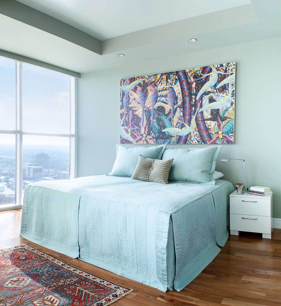 Exemple d'une chambre parentale chic avec un sol en bois brun et un mur bleu.