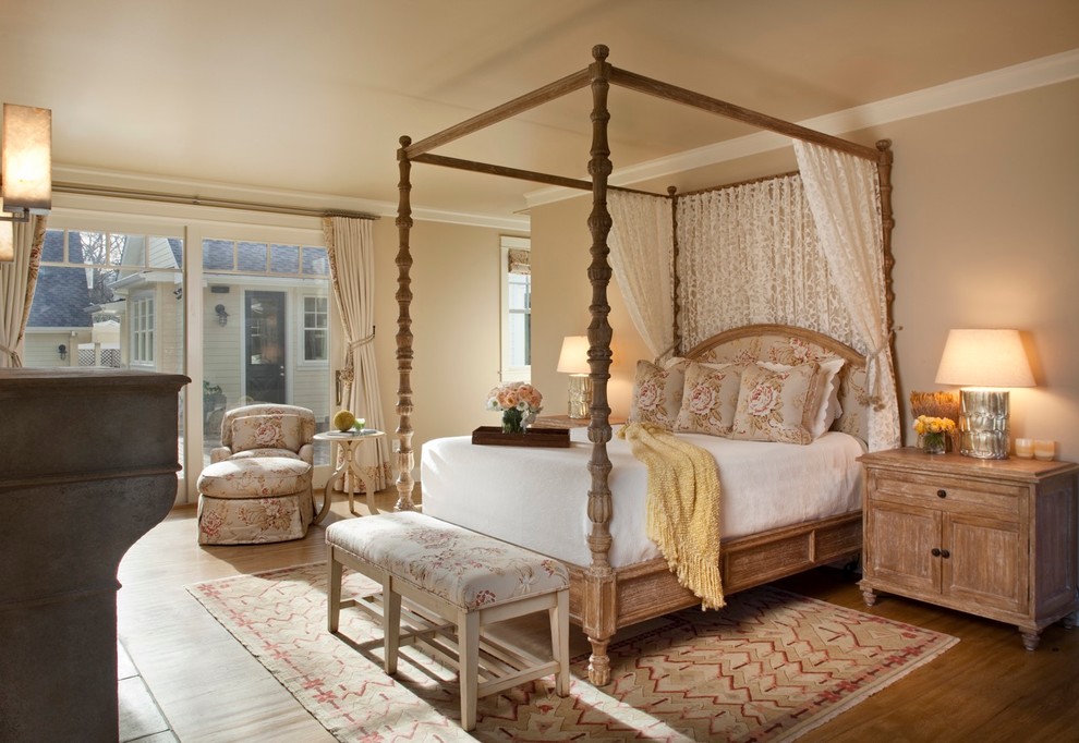 Mittelgroßes Landhaus Hauptschlafzimmer mit beiger Wandfarbe, hellem Holzboden, Kamin, Kaminumrandung aus Beton und braunem Boden in San Francisco