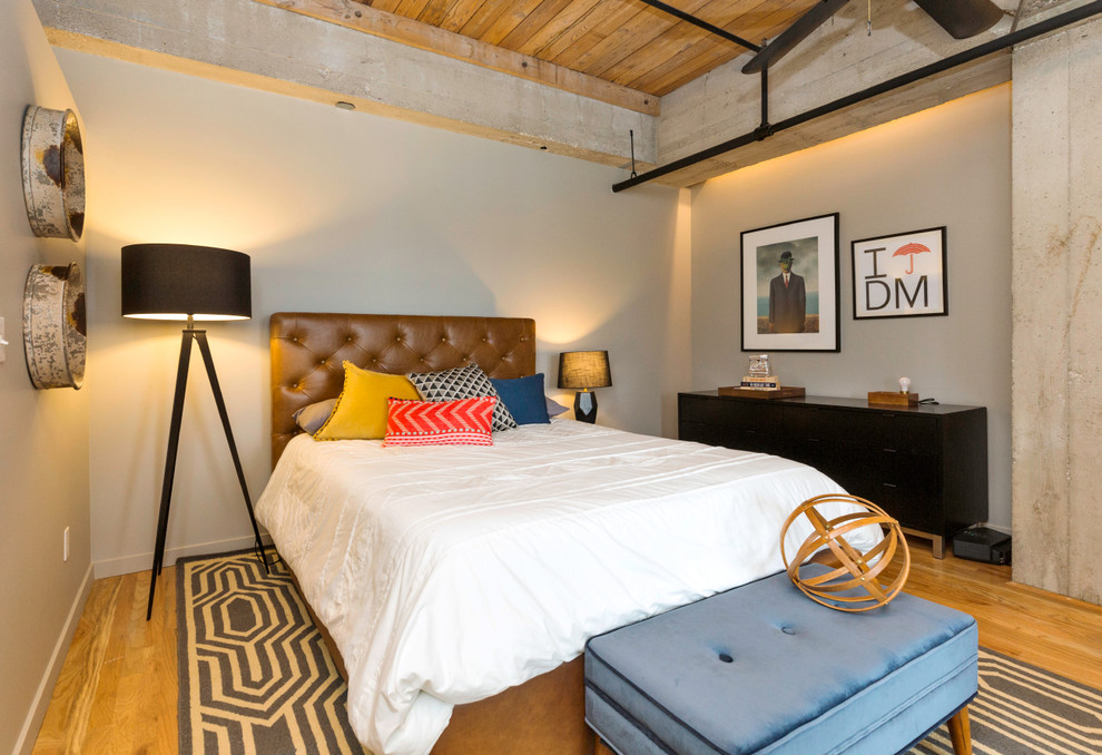 Ejemplo de dormitorio principal tradicional renovado de tamaño medio sin chimenea con paredes grises y suelo de madera en tonos medios