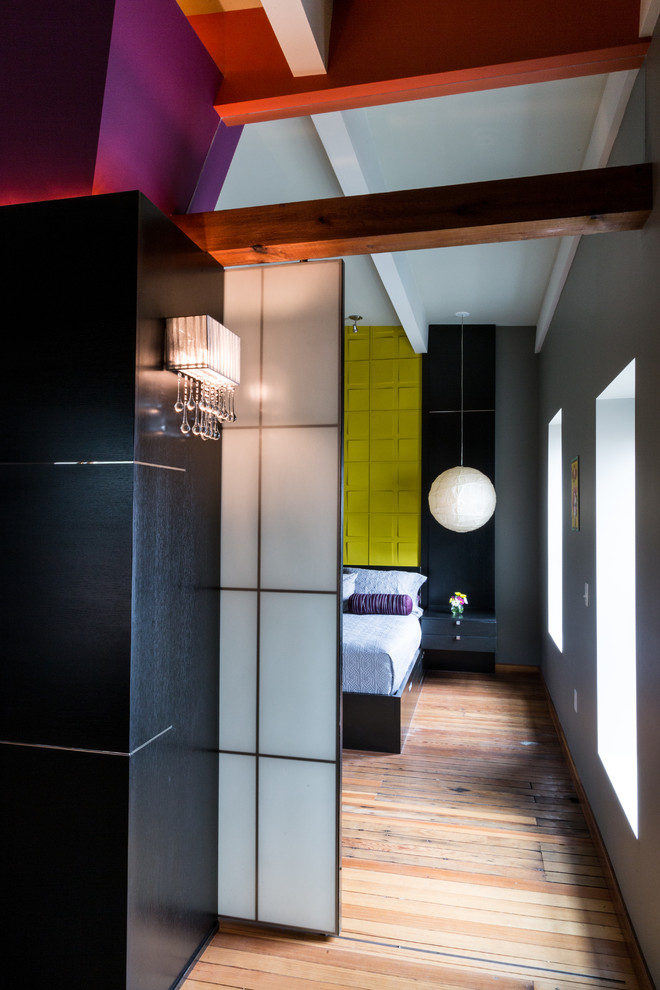 Ejemplo de dormitorio principal urbano de tamaño medio sin chimenea con paredes grises y suelo de madera clara