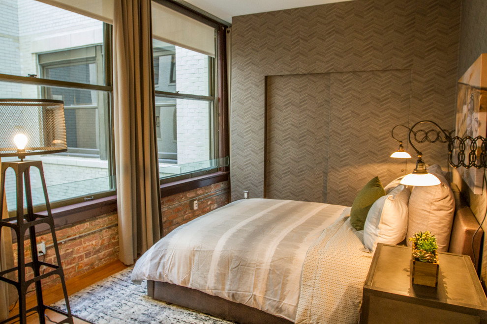 Esempio di una piccola camera da letto stile loft chic con pareti grigie, parquet chiaro, nessun camino e pavimento marrone
