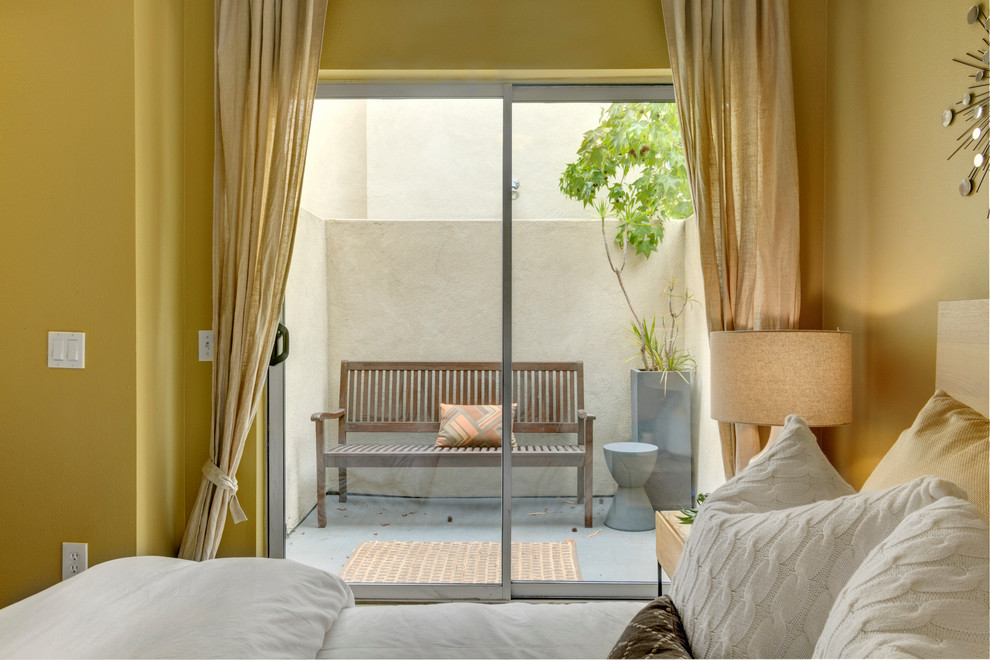 Imagen de dormitorio actual con paredes amarillas