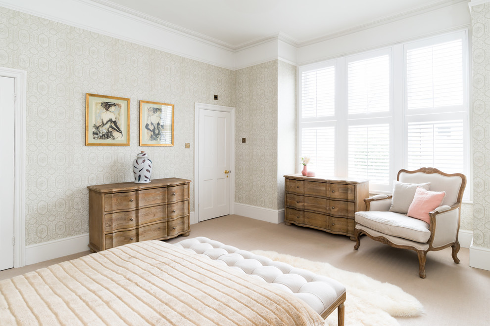 Cette photo montre une grande chambre chic avec un mur beige, une cheminée standard, un manteau de cheminée en pierre et un sol beige.