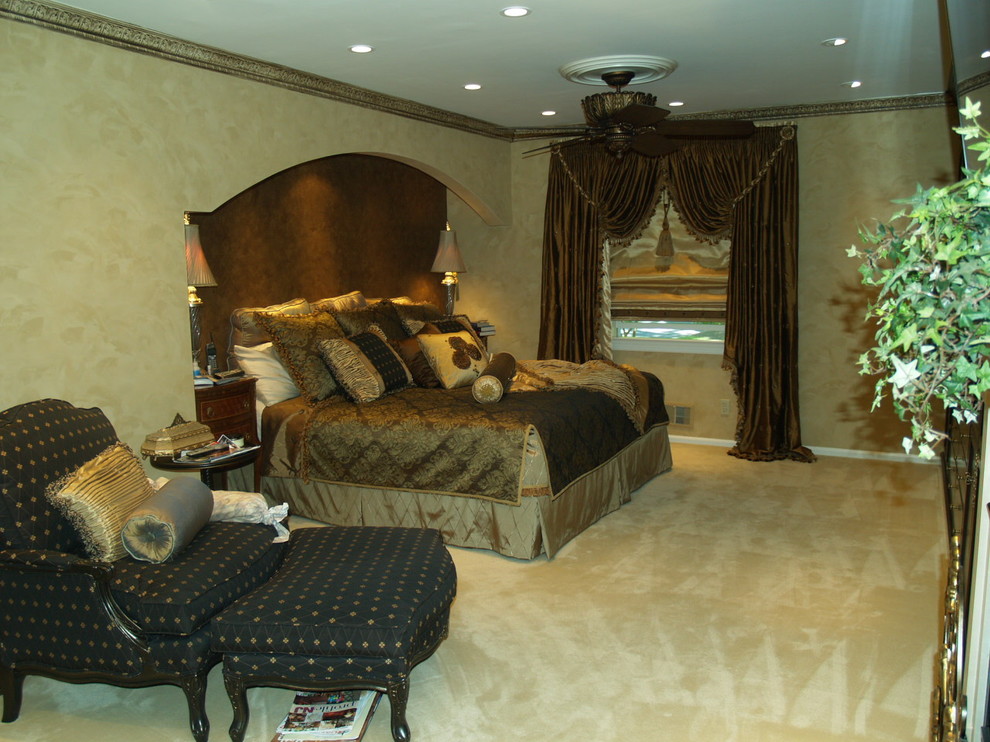 На фото: большая хозяйская спальня в классическом стиле с бежевыми стенами, ковровым покрытием, стандартным камином и бежевым полом с