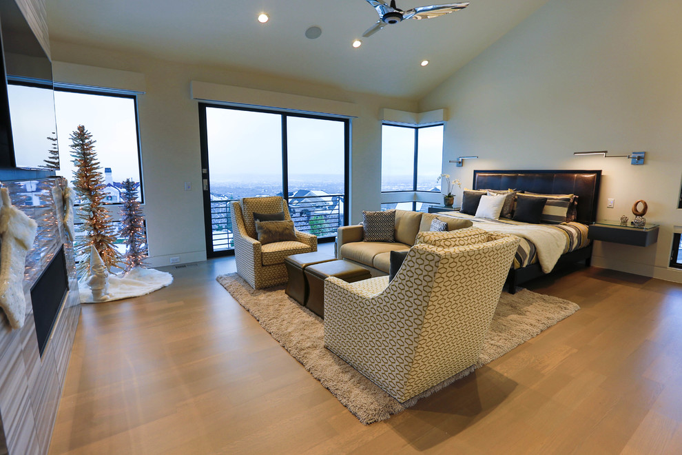 Großes Modernes Hauptschlafzimmer mit beiger Wandfarbe, braunem Holzboden, Gaskamin und gefliester Kaminumrandung in Salt Lake City