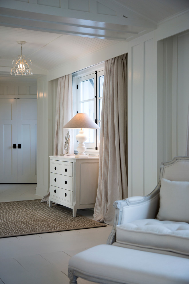 This is an example of a large beach style master bedroom in Montreal with white walls and painted wood flooring.