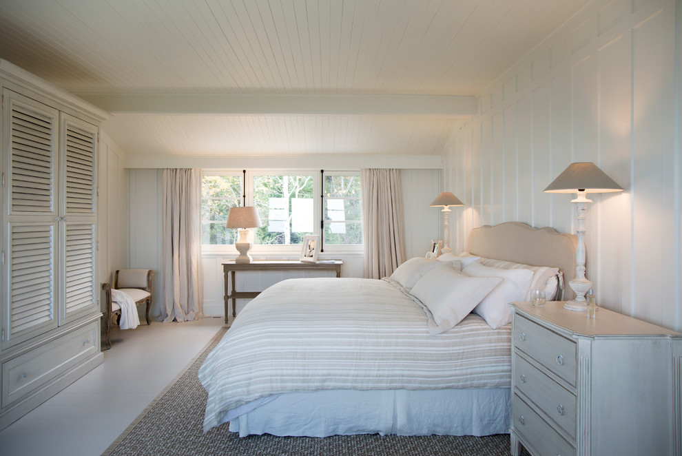 Ejemplo de dormitorio principal costero de tamaño medio con paredes blancas y suelo de madera pintada