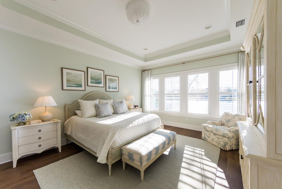 Großes Country Hauptschlafzimmer mit grüner Wandfarbe, braunem Holzboden und braunem Boden in Jacksonville