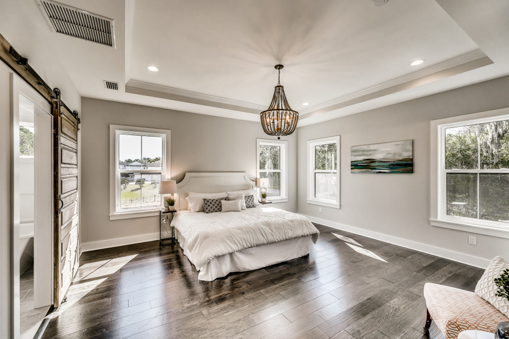Mittelgroßes Landhausstil Hauptschlafzimmer mit grauer Wandfarbe, braunem Holzboden und braunem Boden in Jacksonville