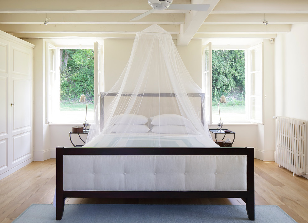 Inspiration för ett vintage sovrum, med beige väggar och ljust trägolv