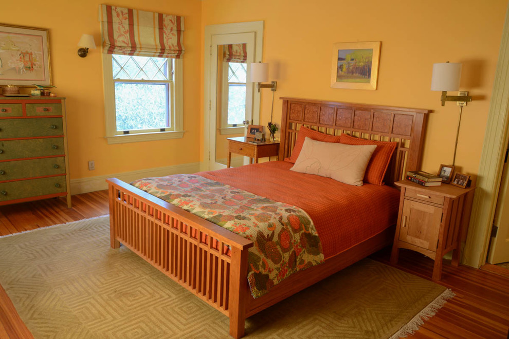 Aménagement d'une grande chambre parentale craftsman avec un mur jaune, un sol en bois brun, une cheminée standard et un manteau de cheminée en carrelage.