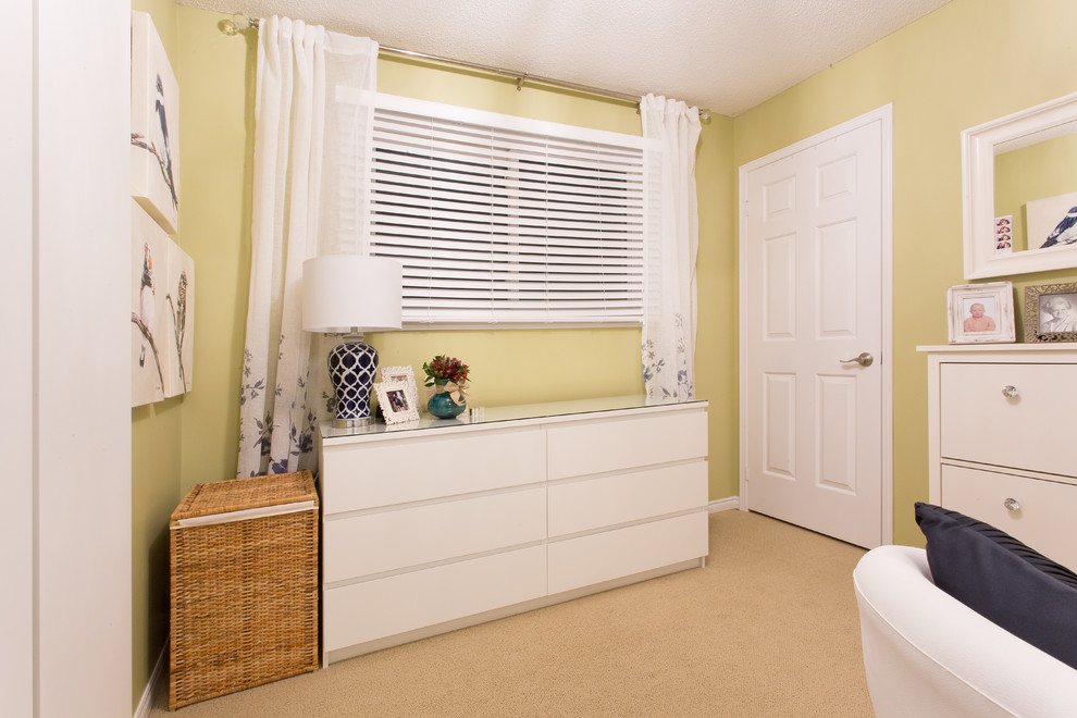 На фото: спальня в современном стиле с желтыми стенами и ковровым покрытием без камина с