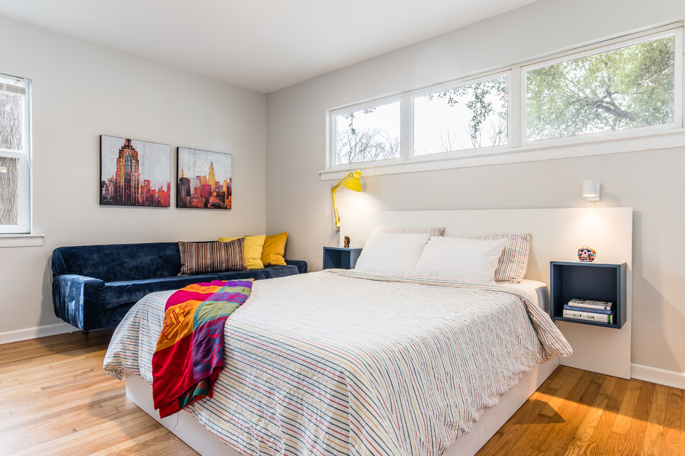 Imagen de dormitorio actual con paredes grises, suelo de madera en tonos medios y suelo marrón