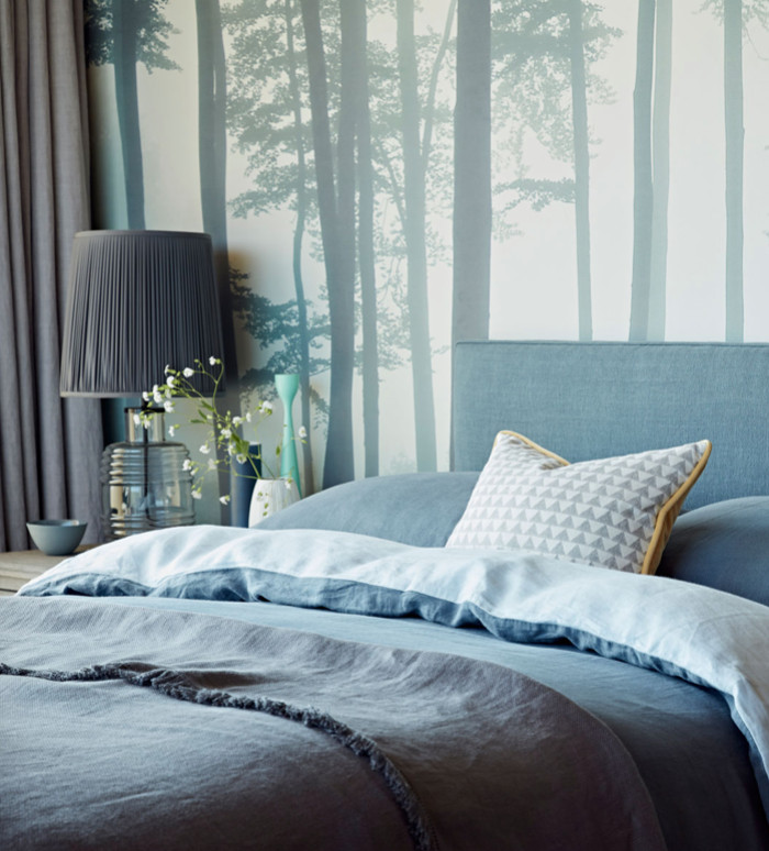 Immagine di una camera da letto minimal con pareti blu e parquet chiaro