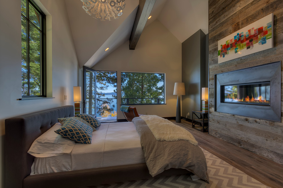 Trendy dark wood floor bedroom photo in San Francisco with beige walls, a ribbon fireplace and a metal fireplace