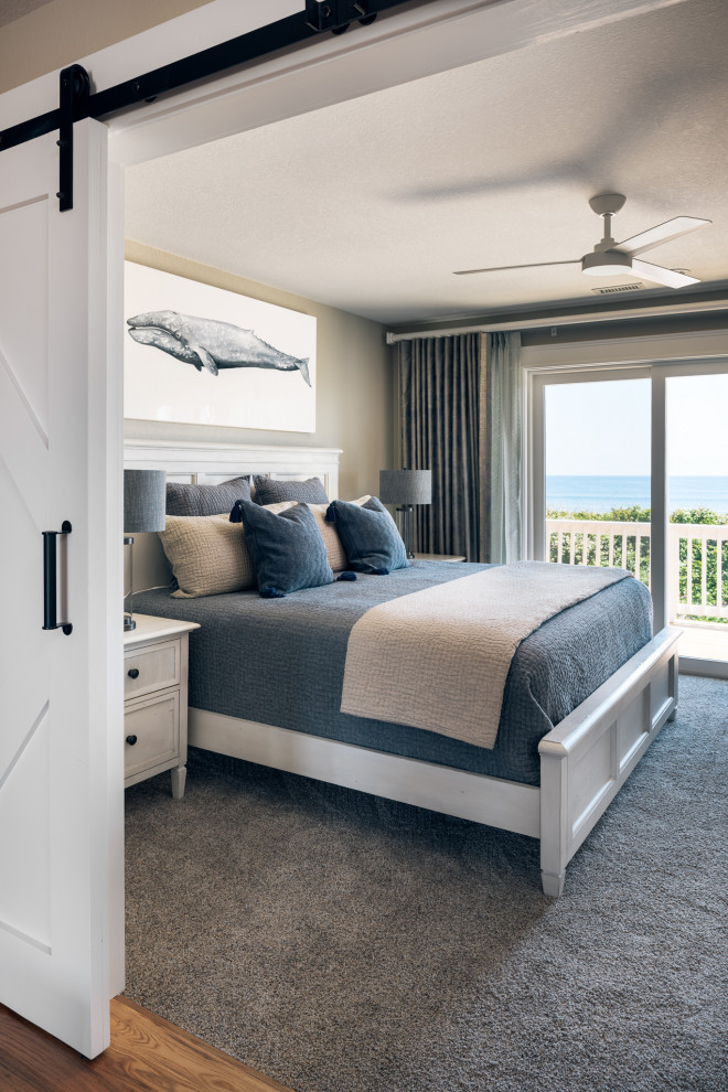 Example of a mid-sized beach style guest carpeted and gray floor bedroom design in Other with beige walls