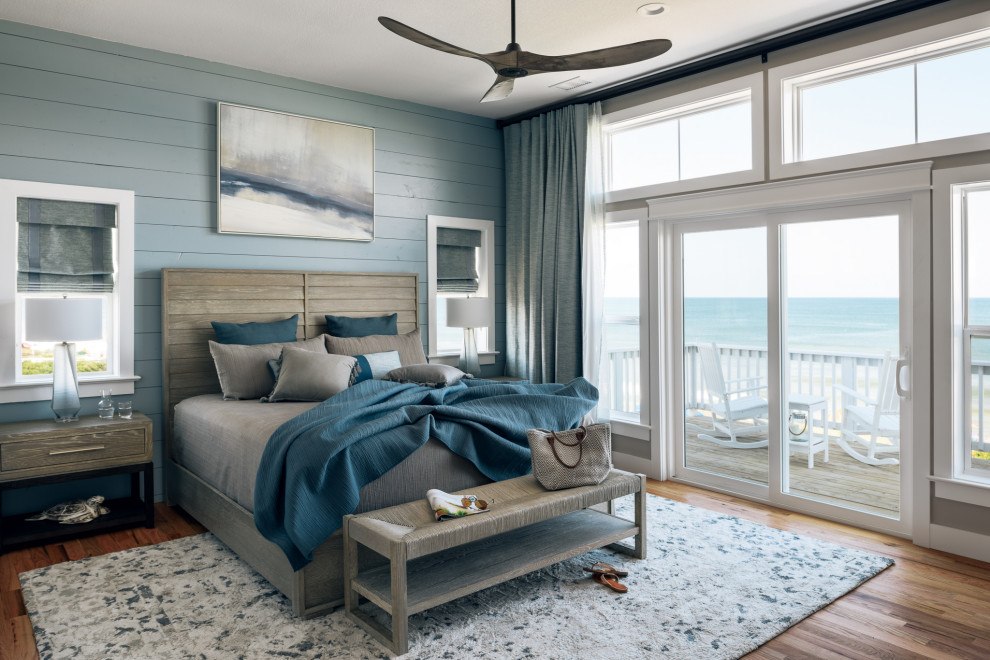 Großes Maritimes Hauptschlafzimmer ohne Kamin mit braunem Holzboden und blauer Wandfarbe in Sonstige