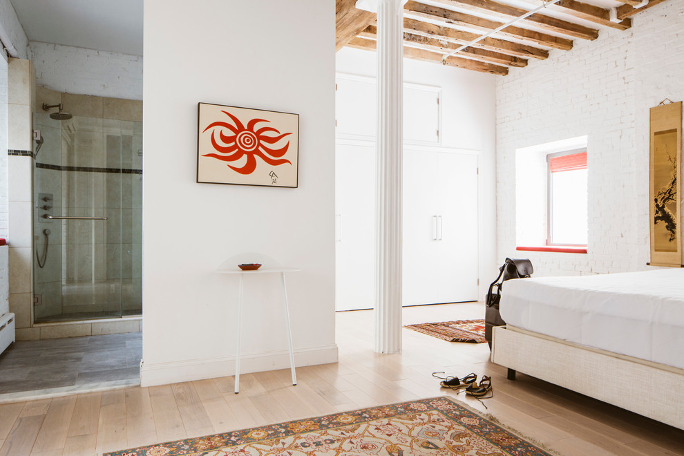 Imagen de dormitorio principal urbano de tamaño medio con paredes blancas y suelo de madera clara