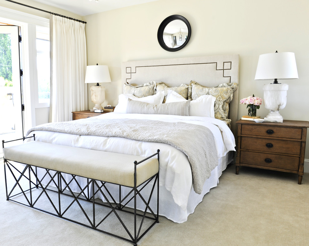 This is an example of a traditional bedroom in Vancouver with beige walls, carpet and green floors.