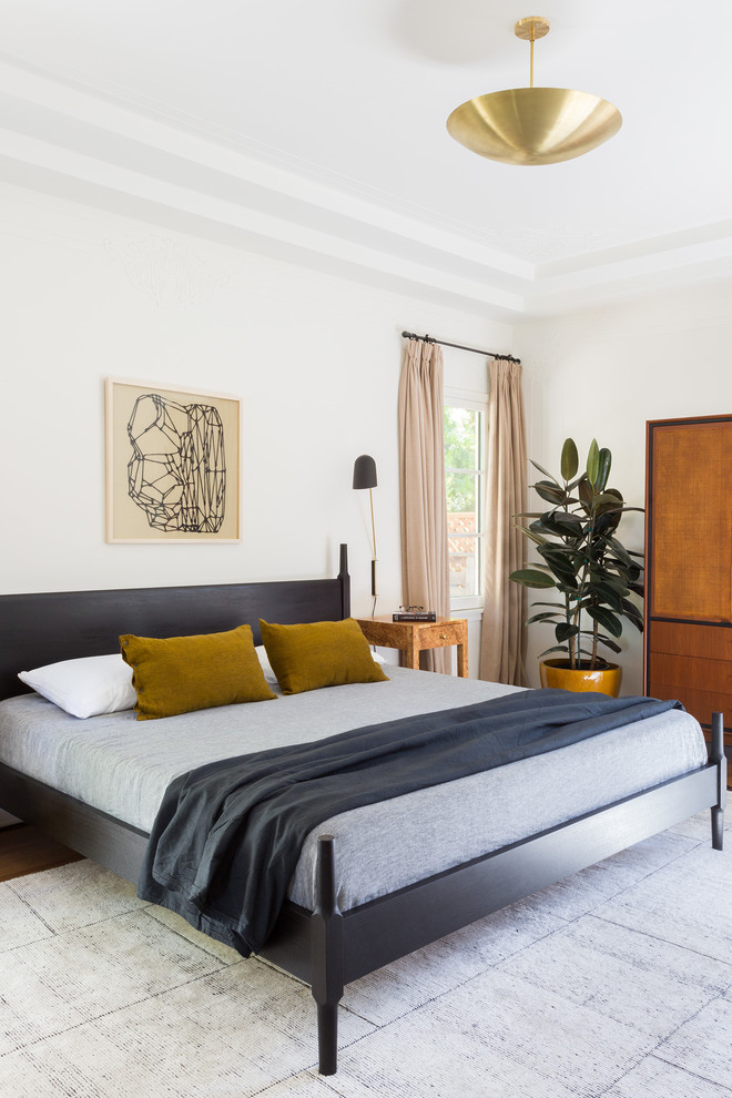 Ejemplo de dormitorio principal mediterráneo de tamaño medio con paredes blancas y suelo de madera en tonos medios