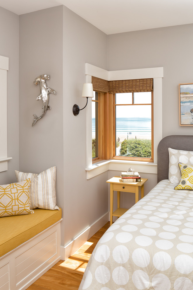 Diseño de habitación de invitados costera de tamaño medio sin chimenea con paredes grises, suelo de madera en tonos medios y suelo marrón
