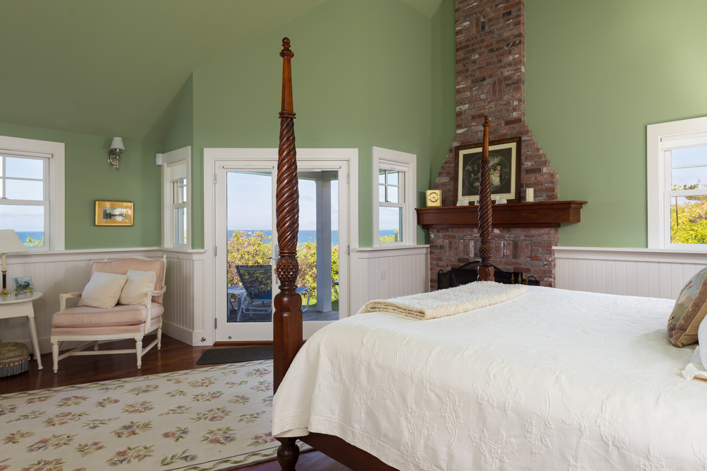 Ejemplo de dormitorio principal marinero de tamaño medio con paredes verdes, suelo de madera oscura, todas las chimeneas y marco de chimenea de ladrillo