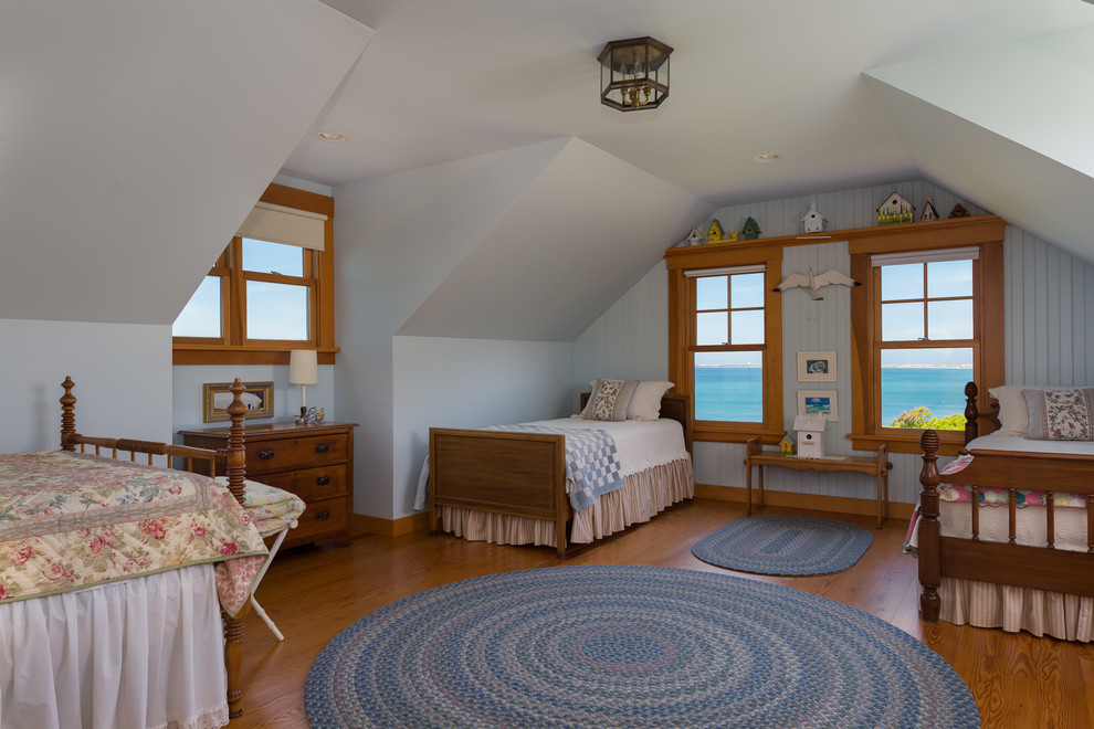 Imagen de habitación de invitados marinera de tamaño medio con paredes azules, suelo de madera en tonos medios y techo inclinado
