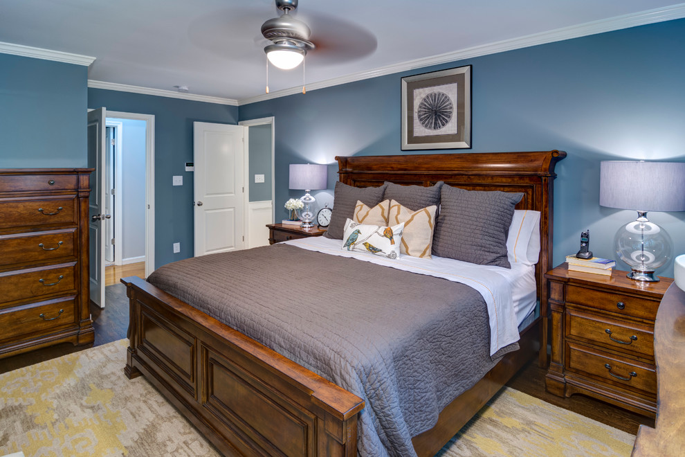 Modelo de dormitorio principal tradicional de tamaño medio sin chimenea con paredes azules y suelo de madera oscura