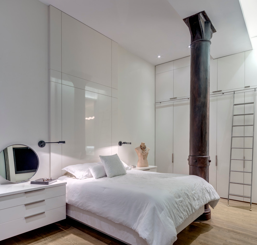 Idée de décoration pour une chambre d'amis minimaliste de taille moyenne avec un mur blanc, un sol en bois brun et aucune cheminée.