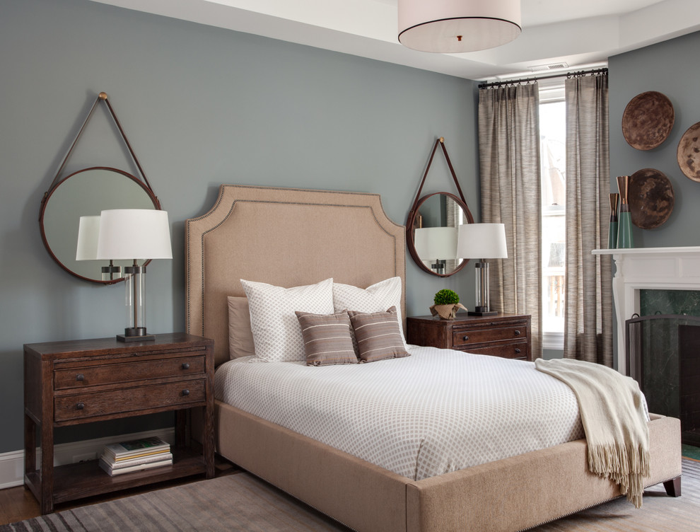 ワシントンD.C.にある中くらいなトランジショナルスタイルのおしゃれな主寝室 (標準型暖炉、青い壁、無垢フローリング、石材の暖炉まわり、茶色い床) のインテリア