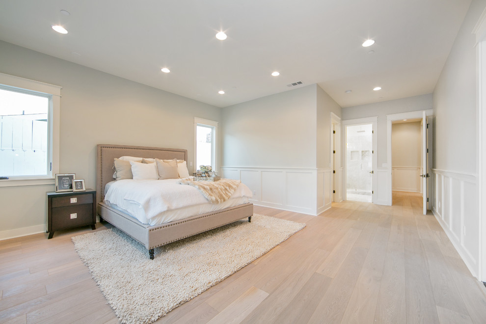 Example of a large transitional master light wood floor bedroom design in Orange County with white walls and no fireplace