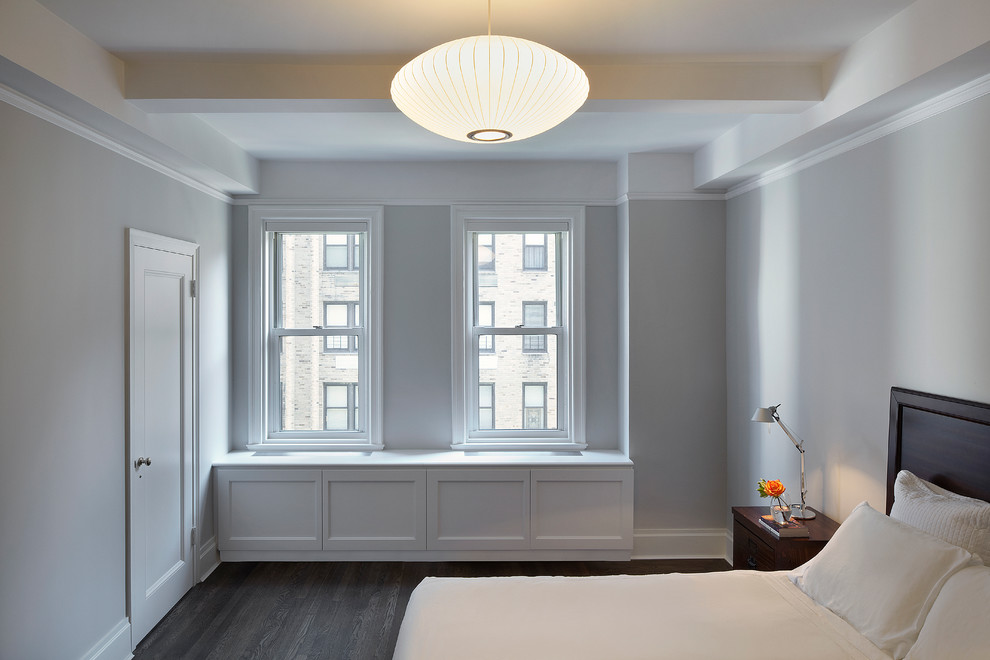 This is an example of a medium sized modern master bedroom in New York with grey walls and medium hardwood flooring.